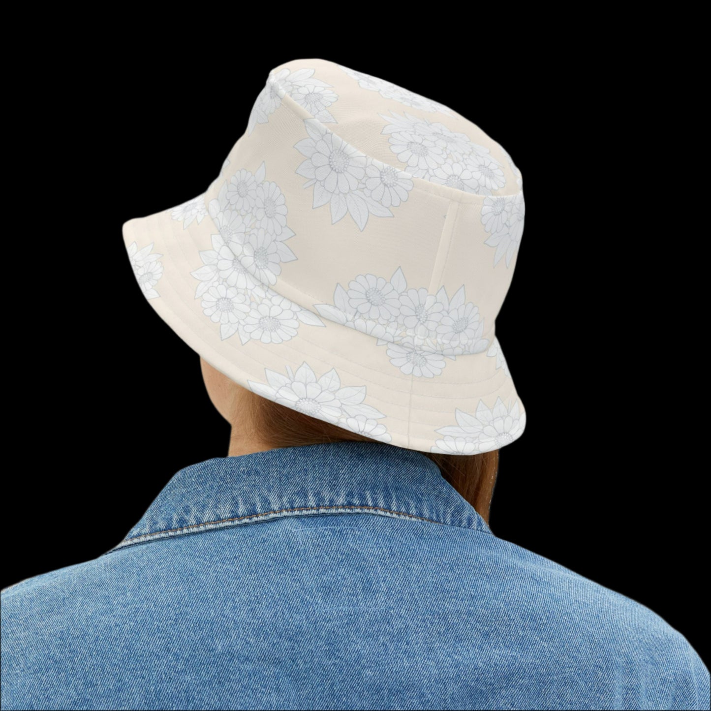 Person wearing a beige bucket hat with white floral patterns on a white background