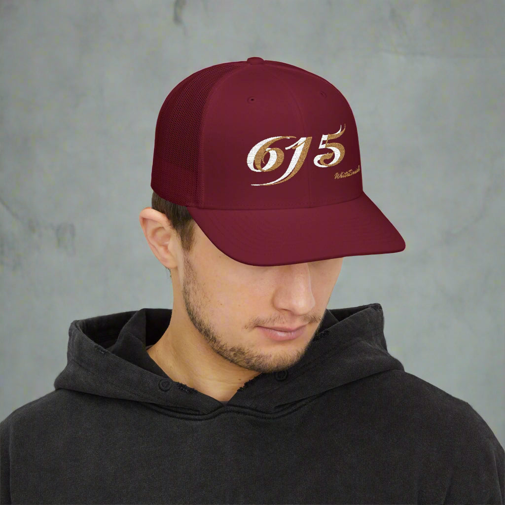 Man wearing a maroon cap with '615' logo on a white background