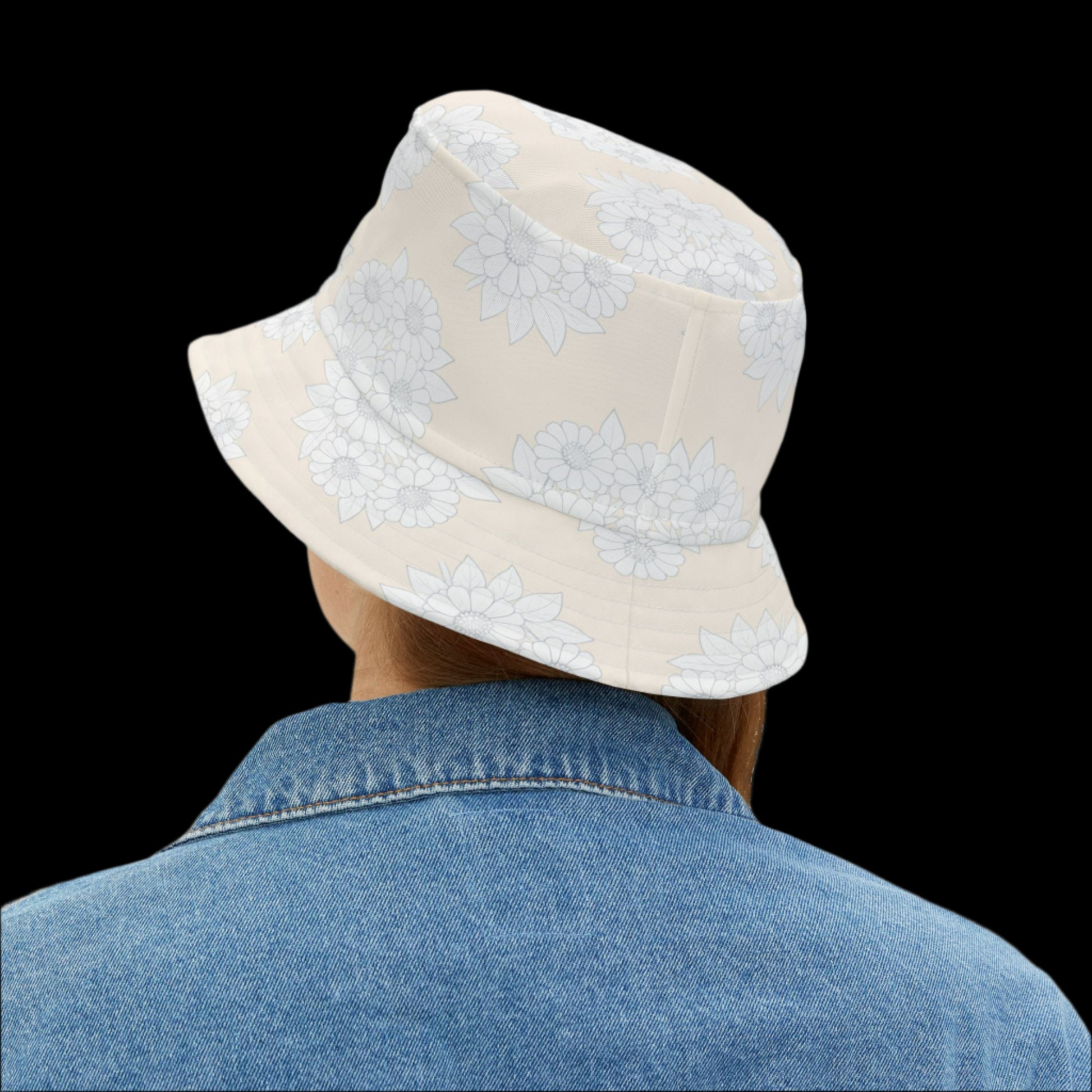 Person wearing a beige bucket hat with white floral patterns on a white background