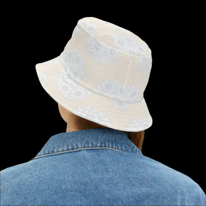 Person wearing a beige bucket hat with white floral patterns on a white background